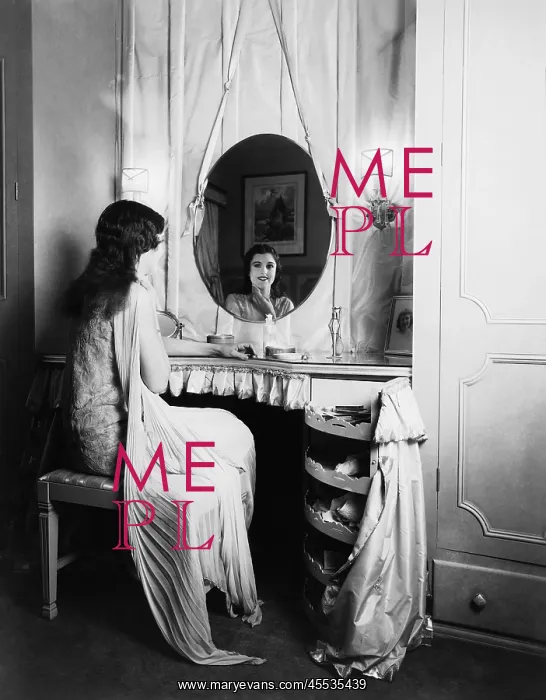 : Woman looking in mirror at dressing table : Woman looking in mirror at dressing table
