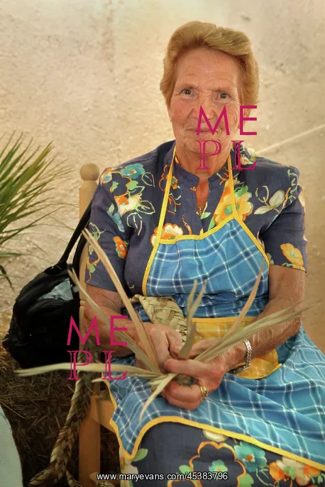 : Woman making a traditional woven strap for a basket : Woman making a traditional woven strap for a basket