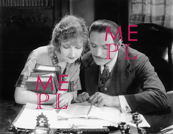 : Woman and man sitting together and looking at a book : Woman and man sitting together and looking at a book