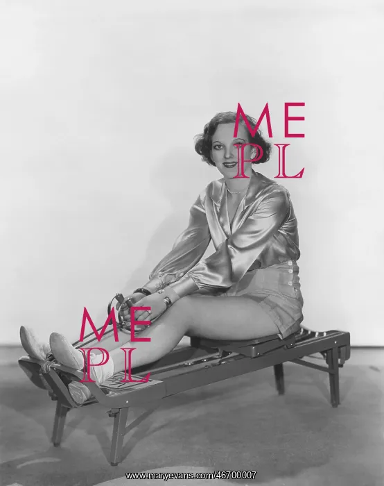 : Woman posing on rowing machine : Woman posing on rowing machine