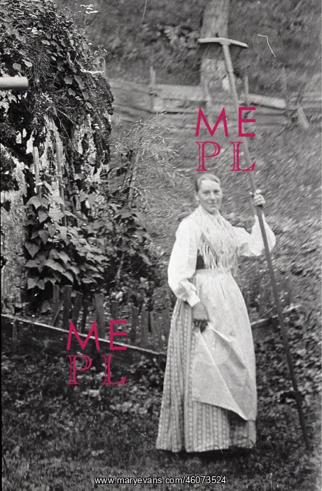 : Woman with a rake with a very long handle. About 1910 : Woman with a rake with a very long handle. About 1910