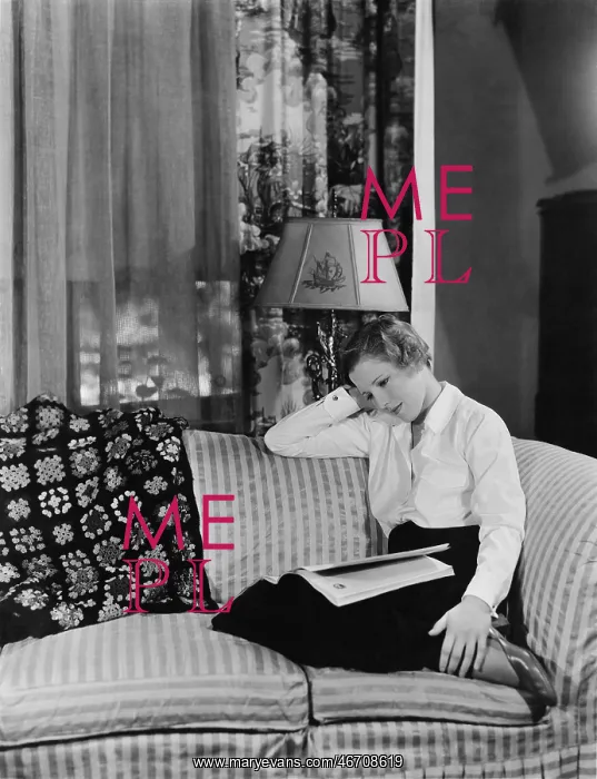 : Woman reading magazine on the sofa : Woman reading magazine on the sofa