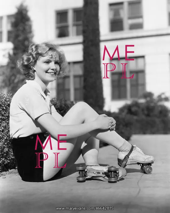 : Woman in roller skates sitting on a sidewalk : Woman in roller skates sitting on a sidewalk
