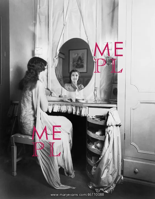 : Woman sitting at her vanity table smiling into the mirror : Woman sitting at her vanity table smiling into the mirror