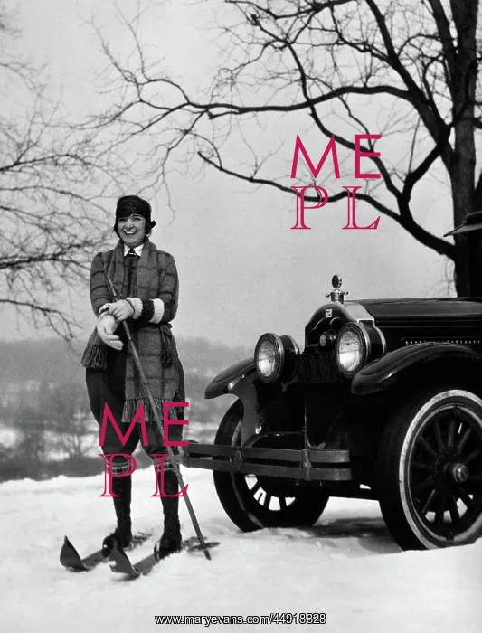 : Woman on skis standing in front of car pulling : Woman on skis standing in front of car pulling