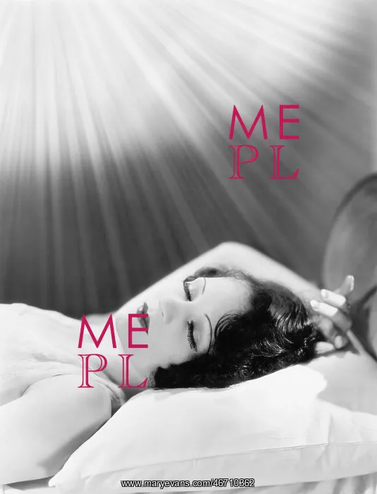 : Woman sleeping in a bed with rays of light shining on her : Woman sleeping in a bed with rays of light shining on her