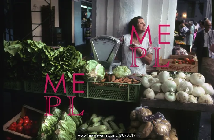 : A woman stallholder behind her vegetable stall, Menorca : A woman stallholder behind her vegetable stall, Menorca