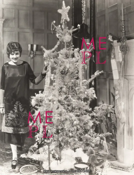 : Woman standing by decorated Christmas tree : Woman standing by decorated Christmas tree