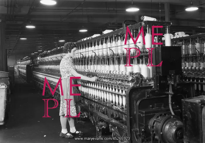 : Woman standing at long row of bobbins, at a textile : Woman standing at long row of bobbins, at a textile