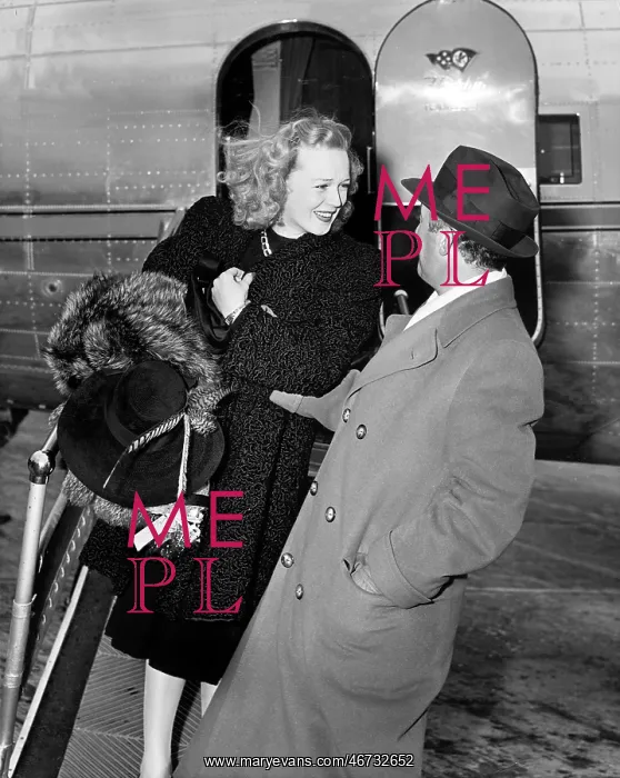: Woman stepping out of a plane being greeted by a man : Woman stepping out of a plane being greeted by a man