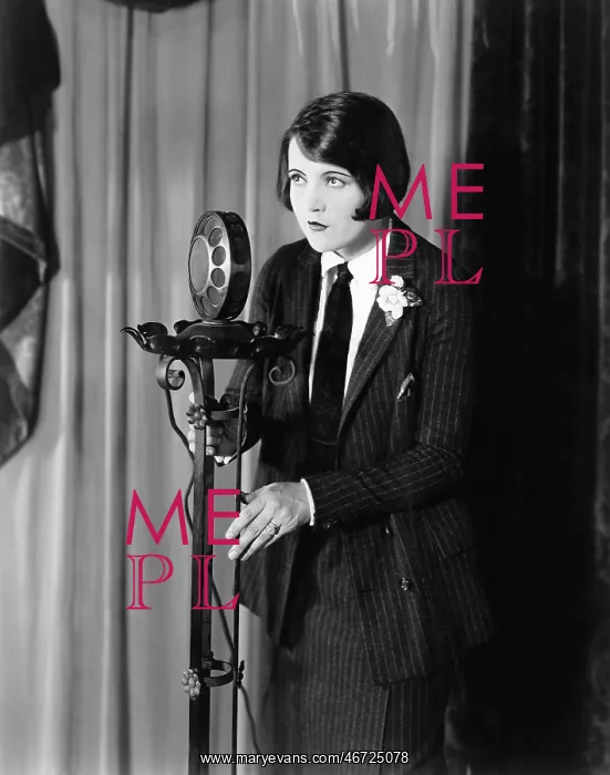 : Woman in suit at microphone : Woman in suit at microphone
