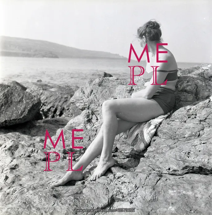 : Woman sunbathing on the rocks in Cornwall : Woman sunbathing on the rocks in Cornwall
