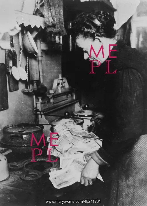 : Woman using banknotes as fuel, Germany 1920s : Woman using banknotes as fuel, Germany 1920s