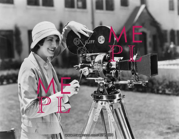 : Woman using movie camera outdoors : Woman using movie camera outdoors