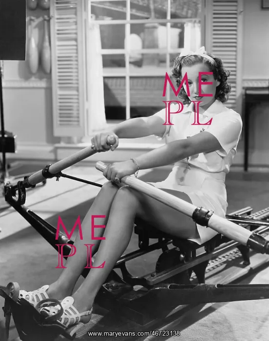 : Woman using rowing machine : Woman using rowing machine
