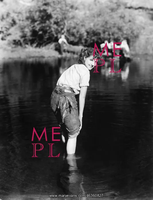 : Woman walking though the water with her pants rolled up : Woman walking though the water with her pants rolled up