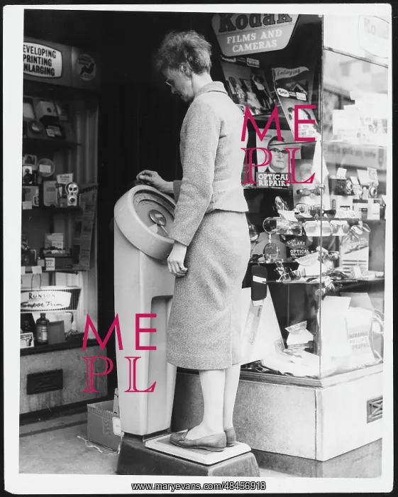 : WOMAN WEIGHING HERSELF : WOMAN WEIGHING HERSELF