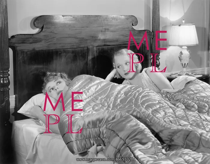 : Two women together in bed under a blanket : Two women together in bed under a blanket