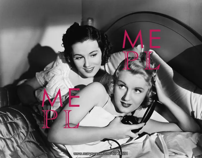 : Two women in bed with telephone : Two women in bed with telephone