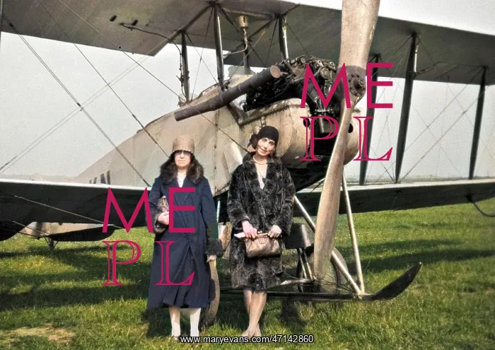 : Two women in front of biplane : Two women in front of biplane