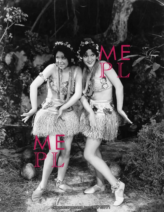 : Two women dancing in grass skirts : Two women dancing in grass skirts