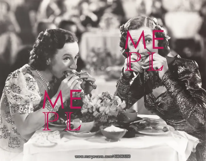 : Two women distracted from their meal : Two women distracted from their meal