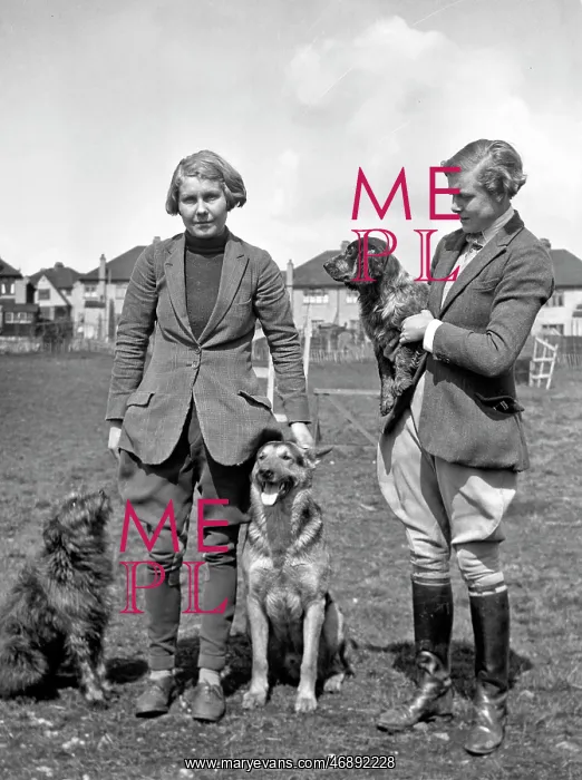  : Two women with three dogs in a field