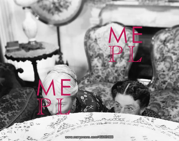 : Two women hiding behind a table and looking over the edge : Two women hiding behind a table and looking over the edge