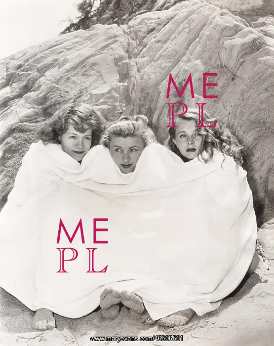 : Three women huddled under a towel on beach : Three women huddled under a towel on beach