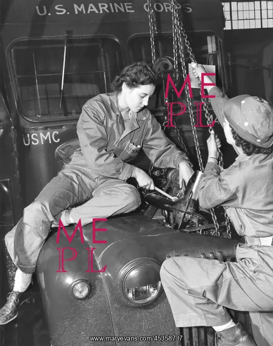 : Women Marines lower a reconditioned engine back : Women Marines lower a reconditioned engine back
