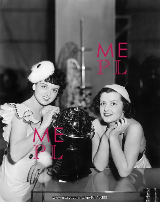 : Two women posing next to a globe : Two women posing next to a globe