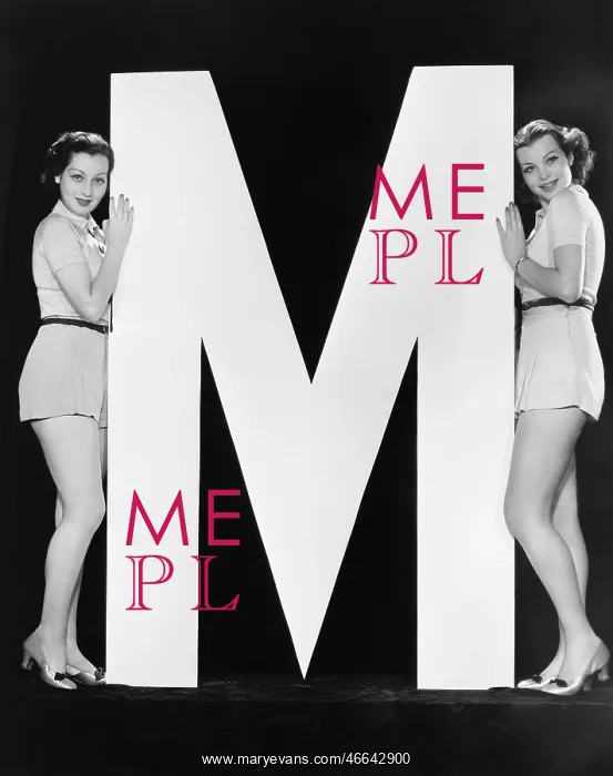 : Two women posing with huge letter M : Two women posing with huge letter M