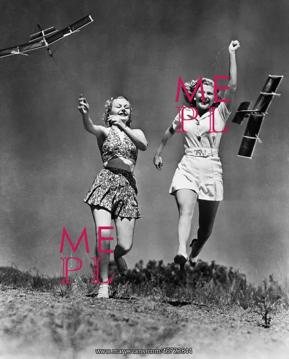 : Two women running and playing with model airplanes : Two women running and playing with model airplanes