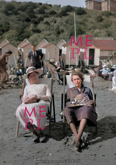 : Two women sitting on a beach : Two women sitting on a beach