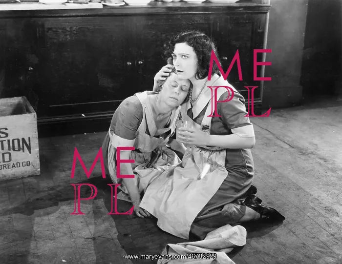 : Two women sitting on the floor while one is holding : Two women sitting on the floor while one is holding