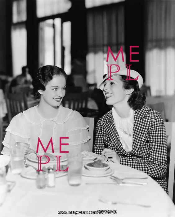 : Two women sitting together in a restaurant : Two women sitting together in a restaurant