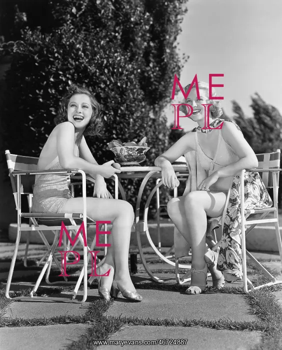 : Two women sitting together in a back yard : Two women sitting together in a back yard