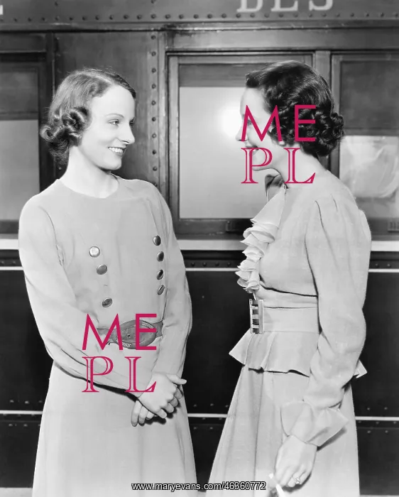  : Two women standing in front of a train and smiling