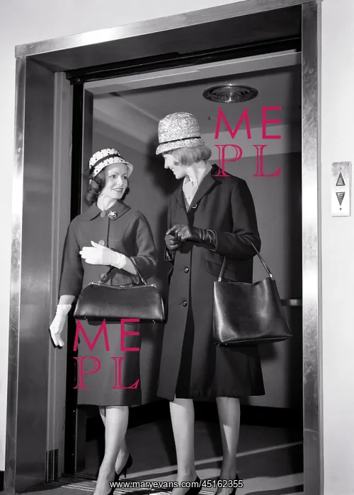 : Two Women Stepping Off Elevator Talking Wearing : Two Women Stepping Off Elevator Talking Wearing