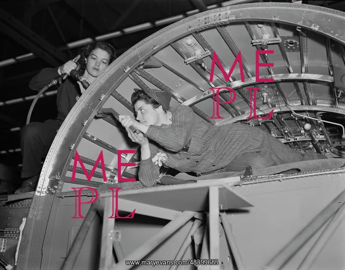 : Women working on a center wing section of : Women working on a center wing section of
