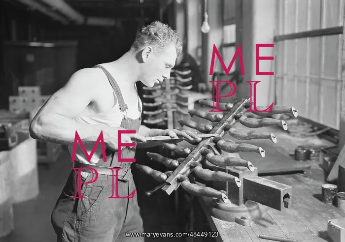 : Worker building rubber doll molds, 1936 : Worker building rubber doll molds, 1936