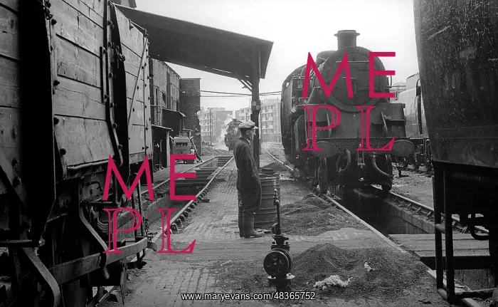 : Worker standing between pits at Nine Elms Loco Yard : Worker standing between pits at Nine Elms Loco Yard