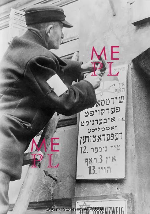 : A worker in the Warsaw Ghetto exchanging a German or Polish- : A worker in the Warsaw Ghetto exchanging a German or Polish-
