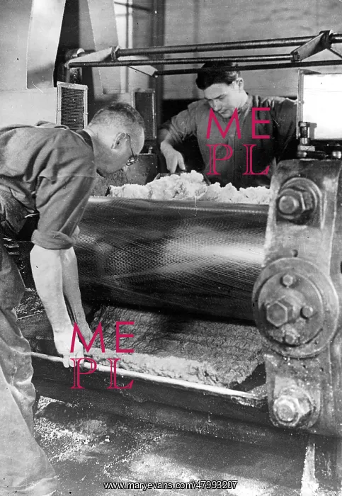  : Workers at a machine producing synthetic rubber