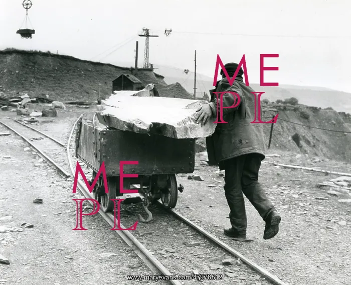 : Workman pushing slate quarry tram, North Wales : Workman pushing slate quarry tram, North Wales