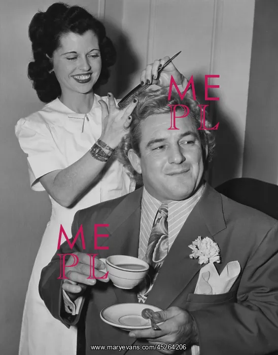 : Wrestler Gorgeous George holding a tea cup as his : Wrestler Gorgeous George holding a tea cup as his