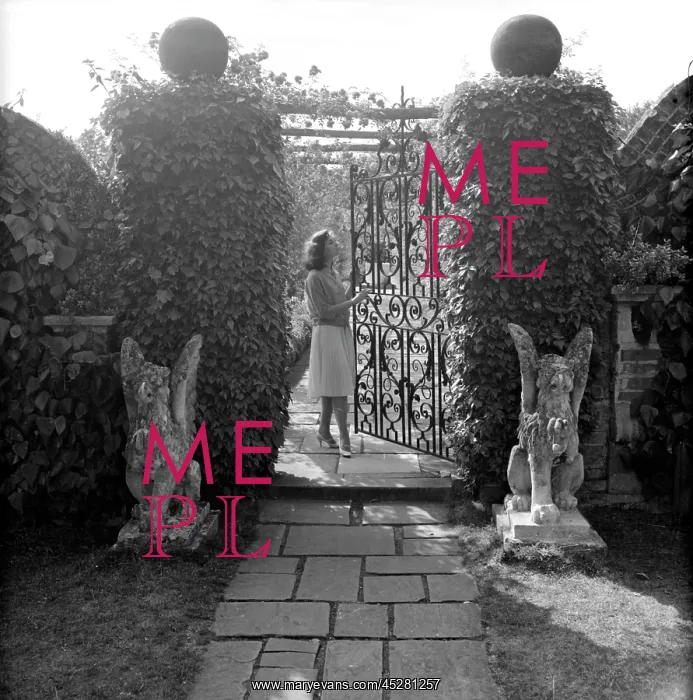  : Wrought iron gate in a garden with female model