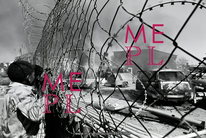 : Two young black children peer through a fence : Two young black children peer through a fence