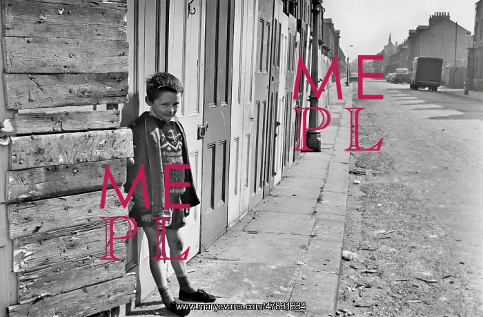 : Young boy in front of boarded up buildings : Young boy in front of boarded up buildings