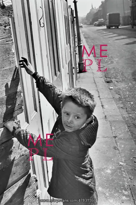 : Young boy in front of boarded up buildings : Young boy in front of boarded up buildings
